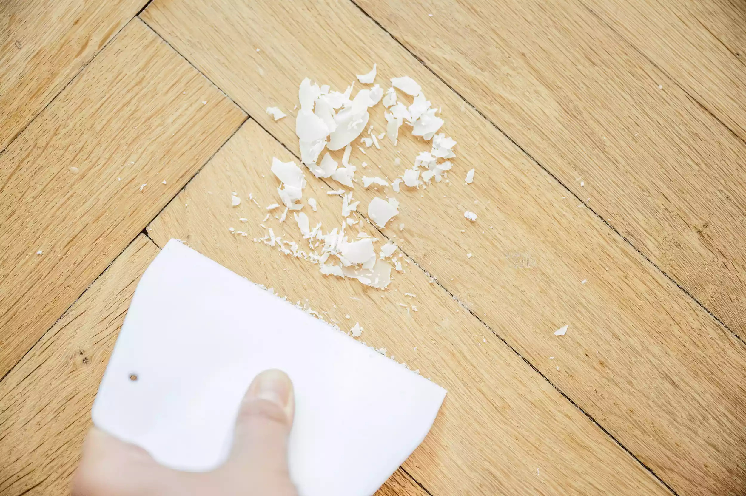 Cạo lớp sáp nến ra khỏi sàn gỗ